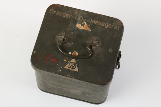 Gerät zum Messen von Kohlendioxid in der Atemluft, hier: Transportbehälter aus Blech, Aufnahme 2022. Fotografie: Amadeus Bramsiepe und Jonas Zilius.
