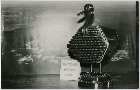 Peter Faulhaber: Deutsches Brüter-Ende, 1991, frühe Dokumentation vor einem Luftbild des Kernforschungszentrums Karlsruhe mit der Titelvariante "Deutsche Brüter Ente". Fotografie: Ulrike Faulhaber.