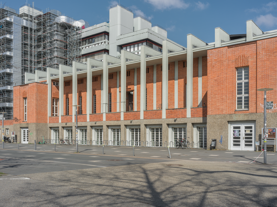 Tribünenbau des Stadions für die Technische Hochschule Karlsruhe, Entwurf: Hermann Alker, Bau ab 1927, fertiggestellt 1931. KIT, Campus Süd, Engesserstraße 20, Ansicht von Südosten, Aufnahme: 2025. Fotografie: Amadeus Bramsiepe und Jonas Zilius.