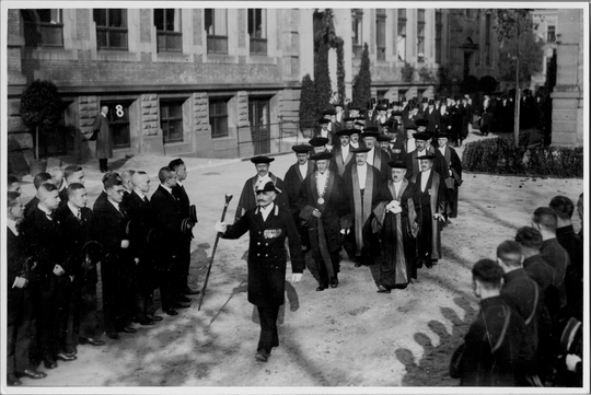Festzug der Professoren bei der 100-Jahr-Feier der Technischen Hochschule Karlsruhe, hinter dem Hochschuldiener mit Szepterstab der Rektor Theodor Rehbock mit der Rektorkette, 30.10.1925. Fotografie unbekannter Urheberschaft. KIT-Archiv 28010/I 1601.