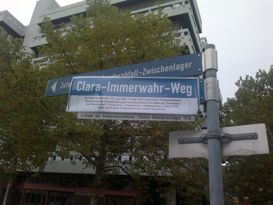 Das Straßenschild am "Fritz-Haber-Weg" auf dem Campus Süd des KIT wurde im Oktober 2012 mit einem den Namen von Habers erster Ehefrau Clara Immerwahr tragenden Imitat überdeckt. Ihr Suizid im Jahr 1915 wurde auch mit dem kurz zuvor von Haber geleiteten Giftgaseinsatz in Verbindung gebracht. Fotografie: Klaus Nippert.